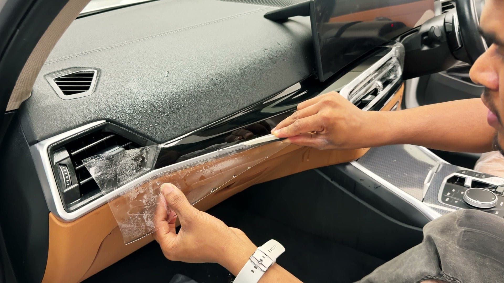 Protective film being fitted to the dashboard trim of a BMW 330Li