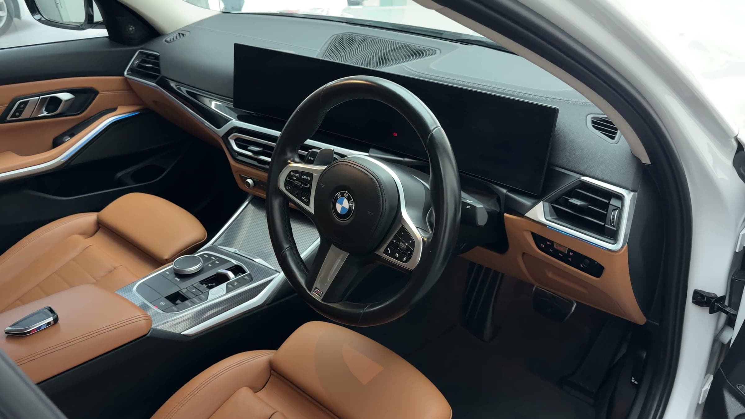 Tan leather interior and curved display of a BMW 330Li