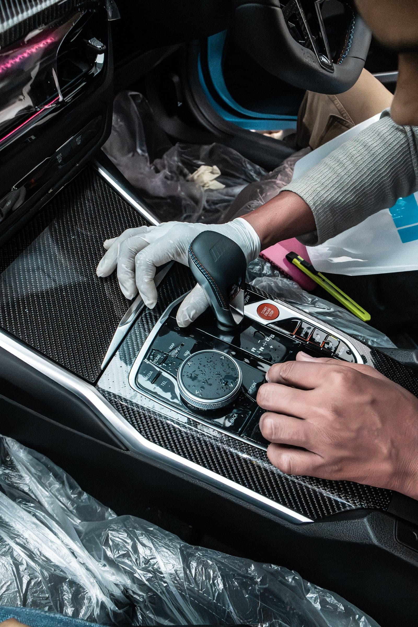 Film being applied to the carbon-fibre centre console of a BMW M2