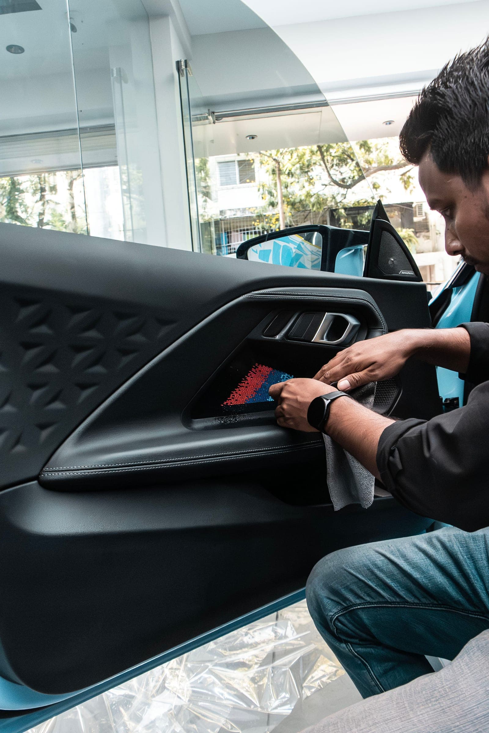 Interior protection film being applied to the door trim of a BMW M2