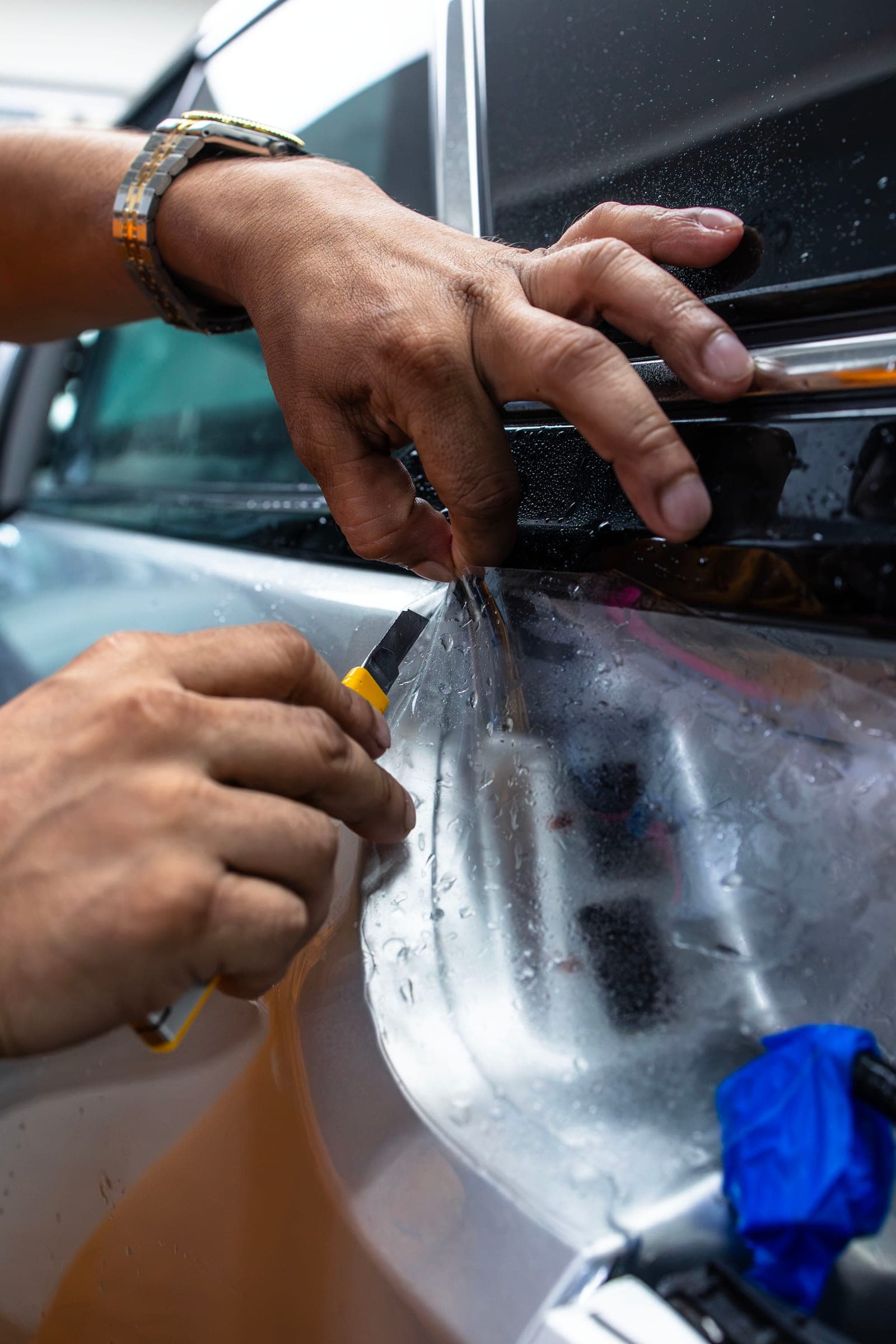 Close-up of paint protection film being trimmed along a door edge