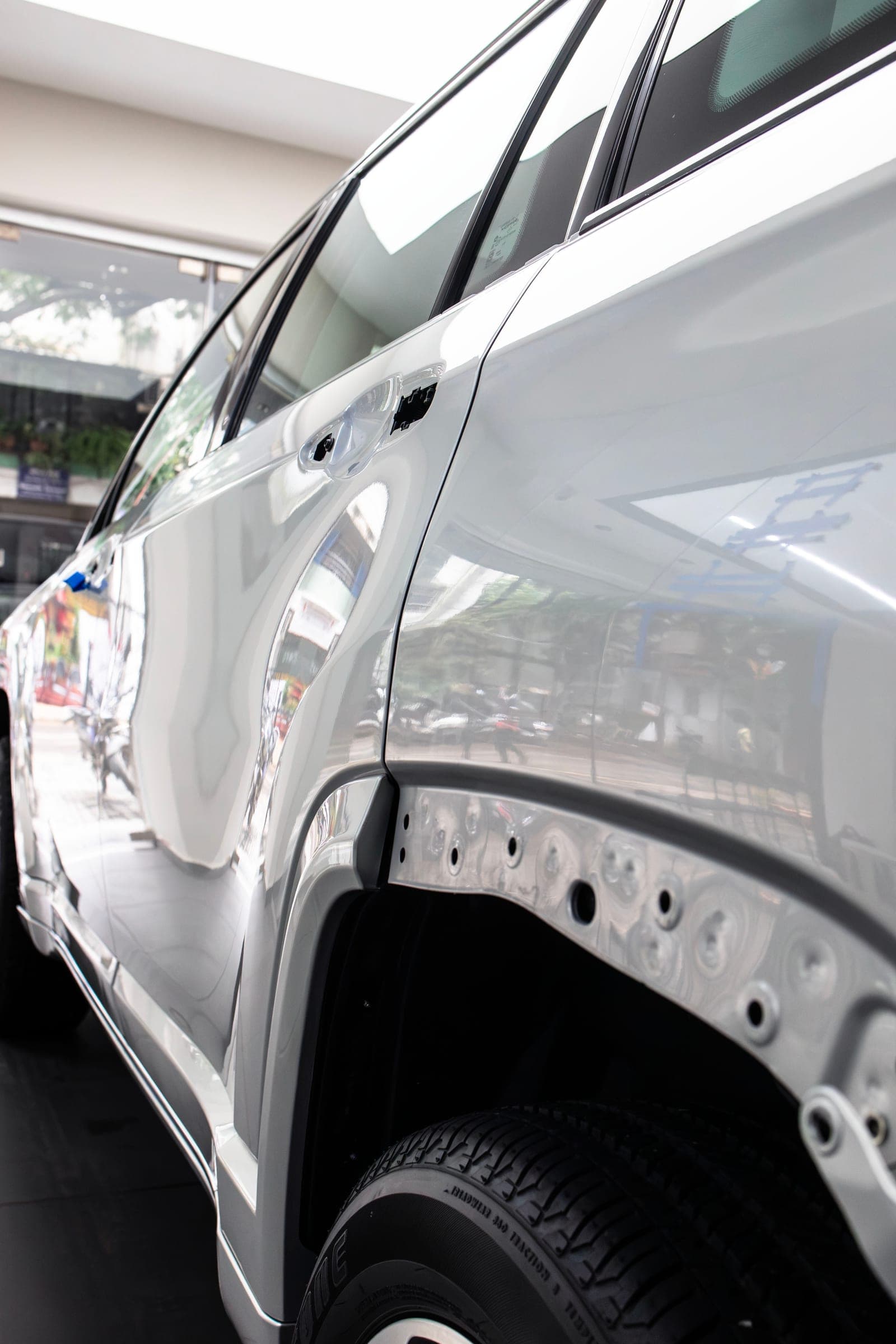 Rear quarter panel and wheel of a white BYD prepared for film