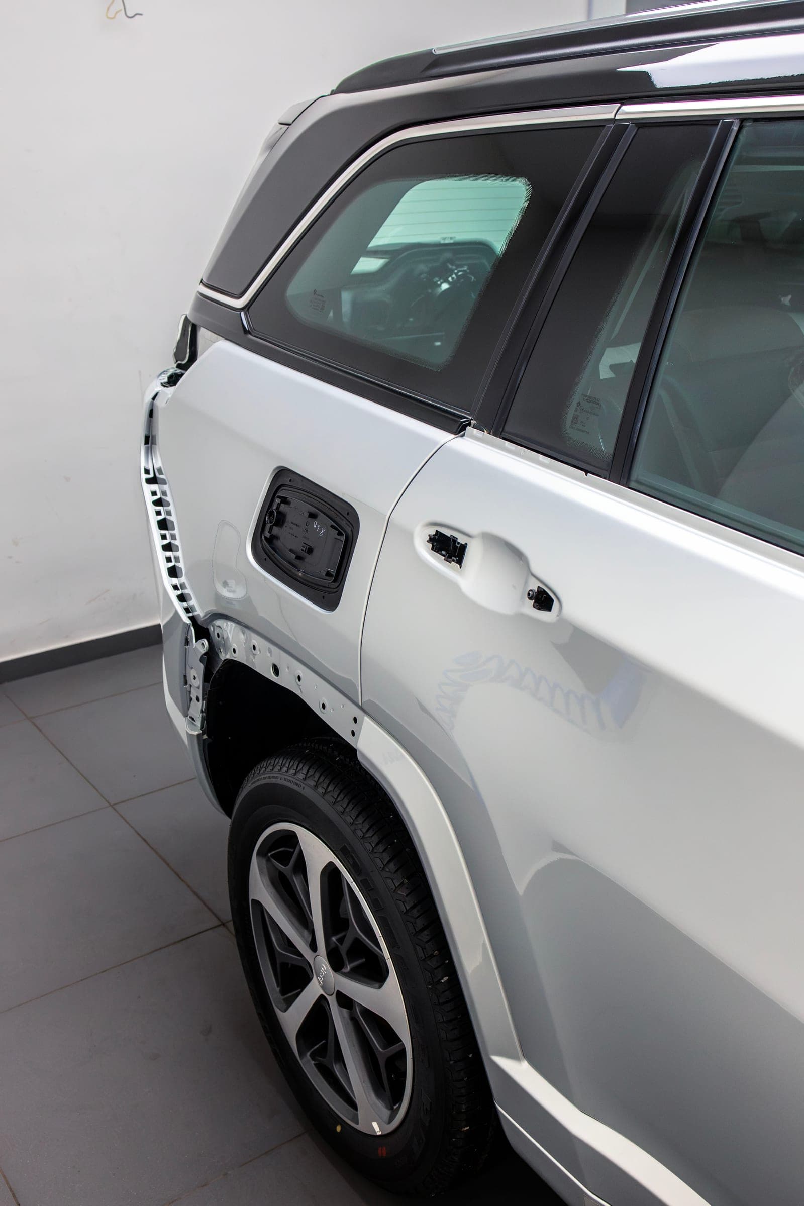 Side of a white BYD with trim removed ahead of film installation
