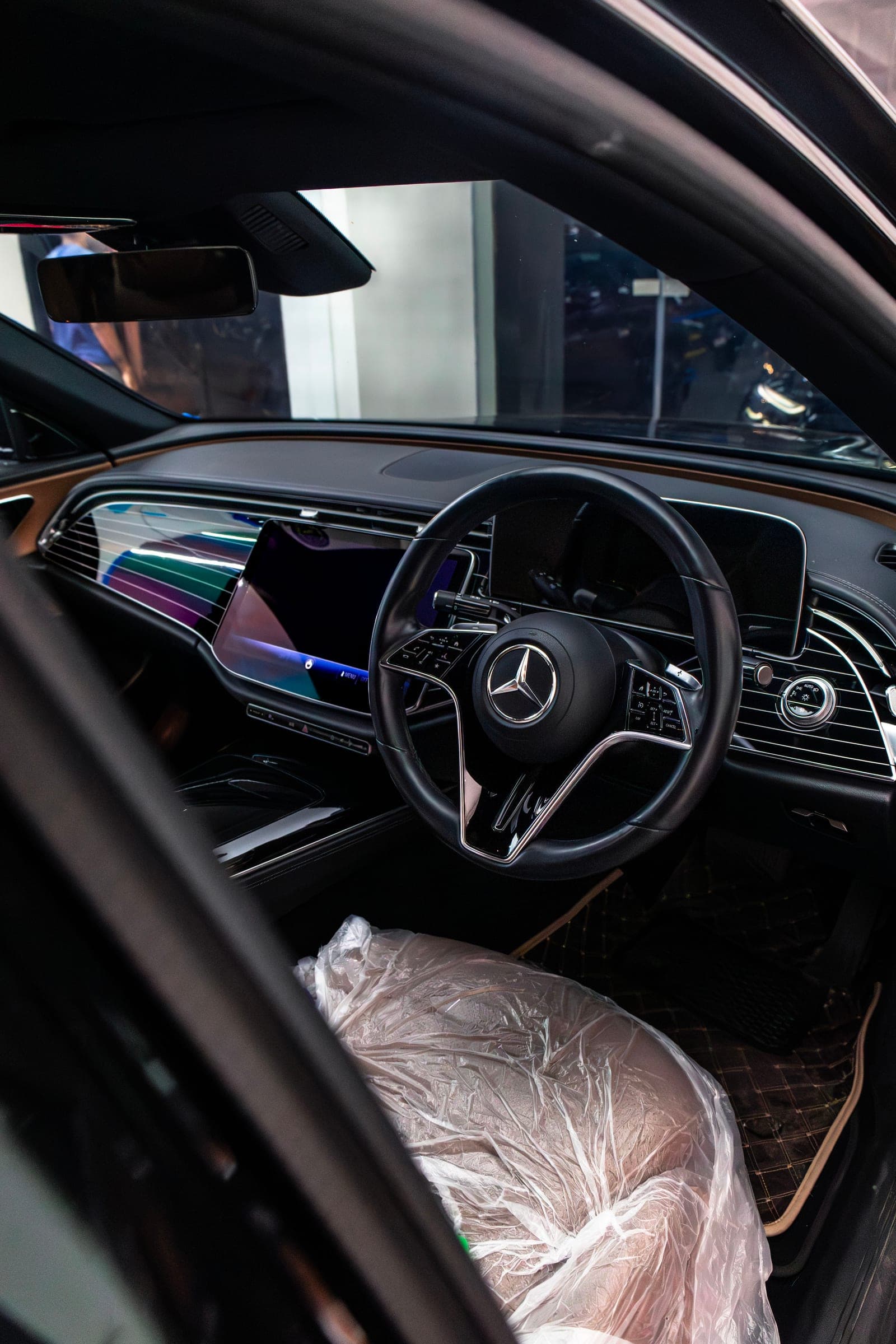 Driver's side of a Mercedes-Benz E 450 cabin with the screens lit