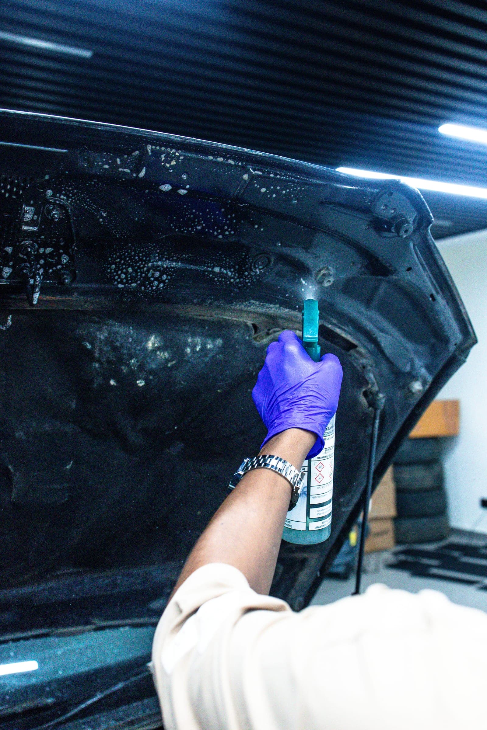 Technician dressing the underside of the bonnet with a small applicator