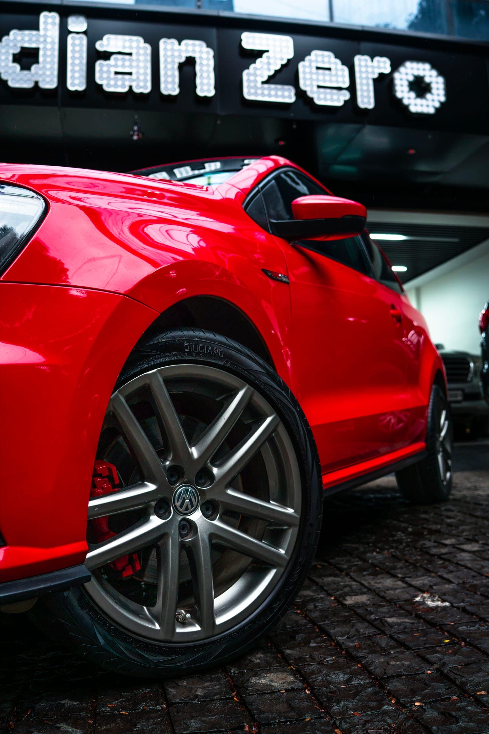 Alloy wheel and red caliper of a Polo GT below the studio sign