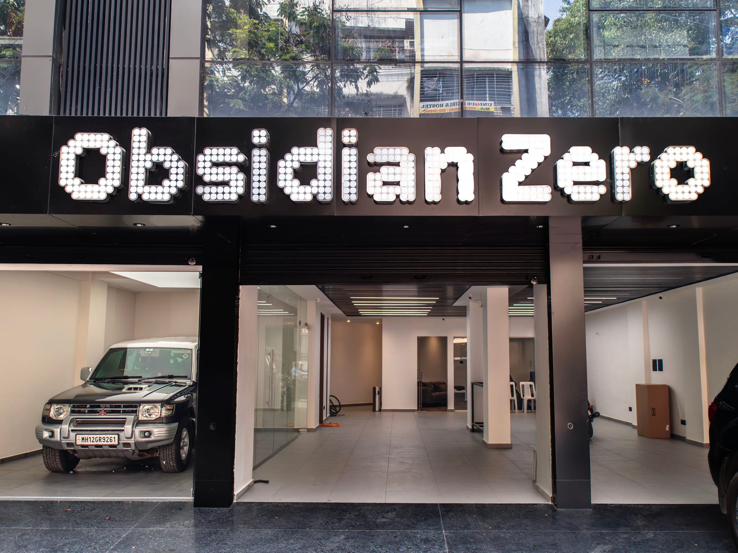 Illuminated Obsidian Zero dot-matrix sign above the glass studio front in Pune