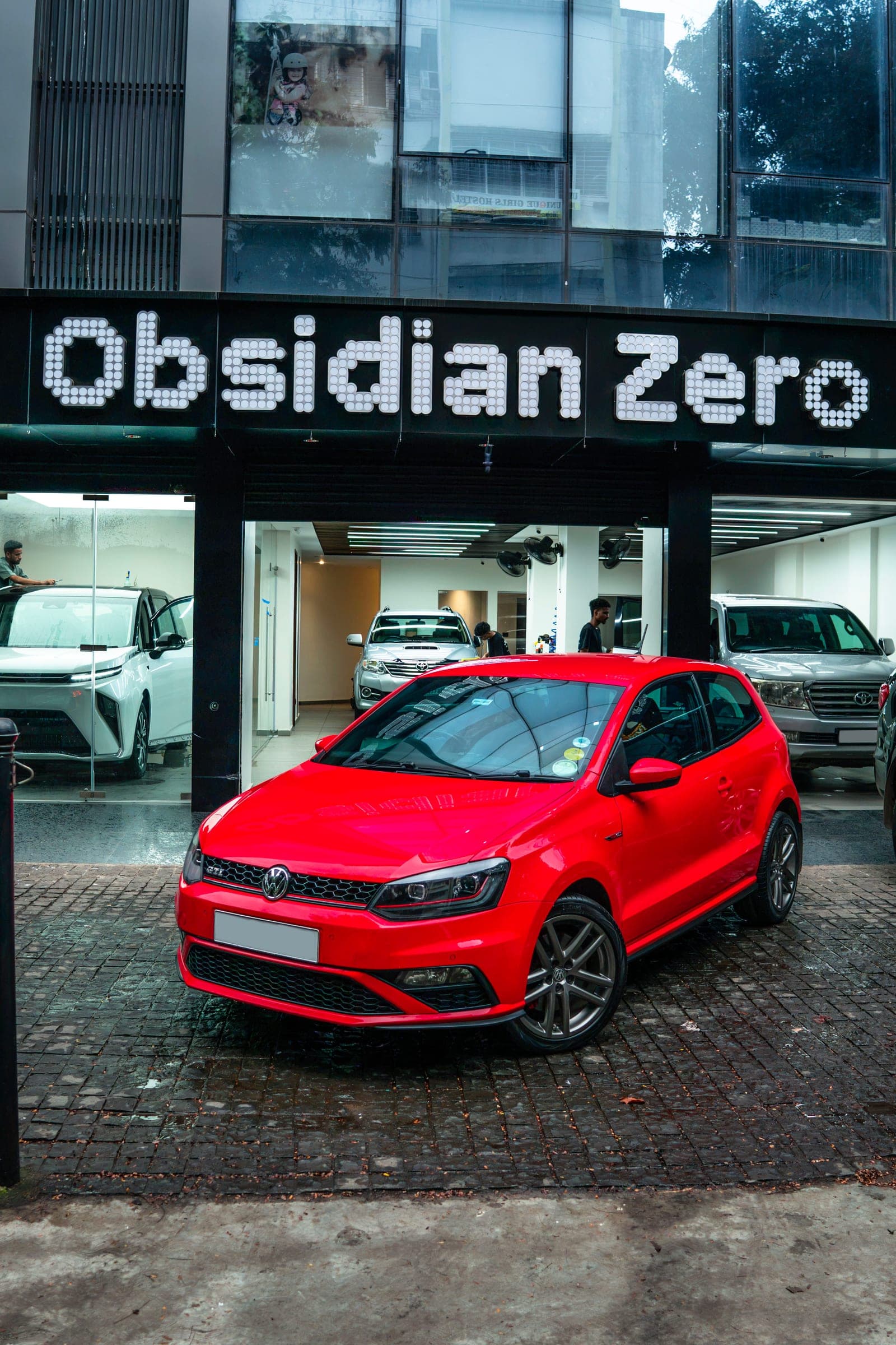 Red Volkswagen Polo GT on wet cobbles outside the Obsidian Zero studio