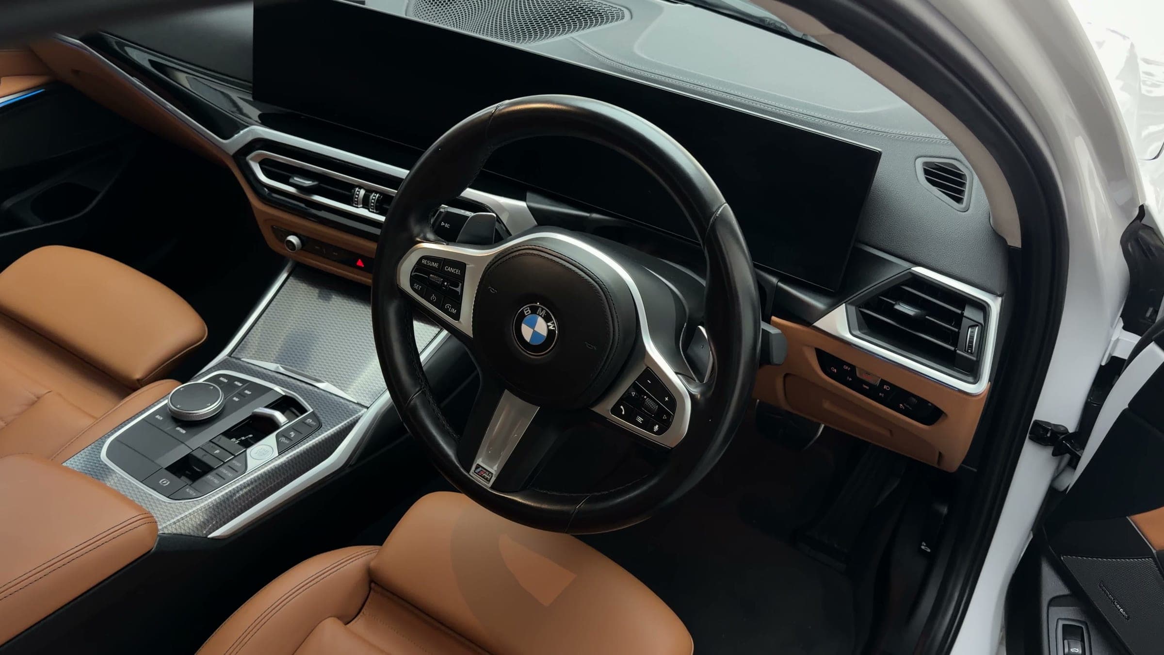 Steering wheel and tan leather seats of a BMW 330Li
