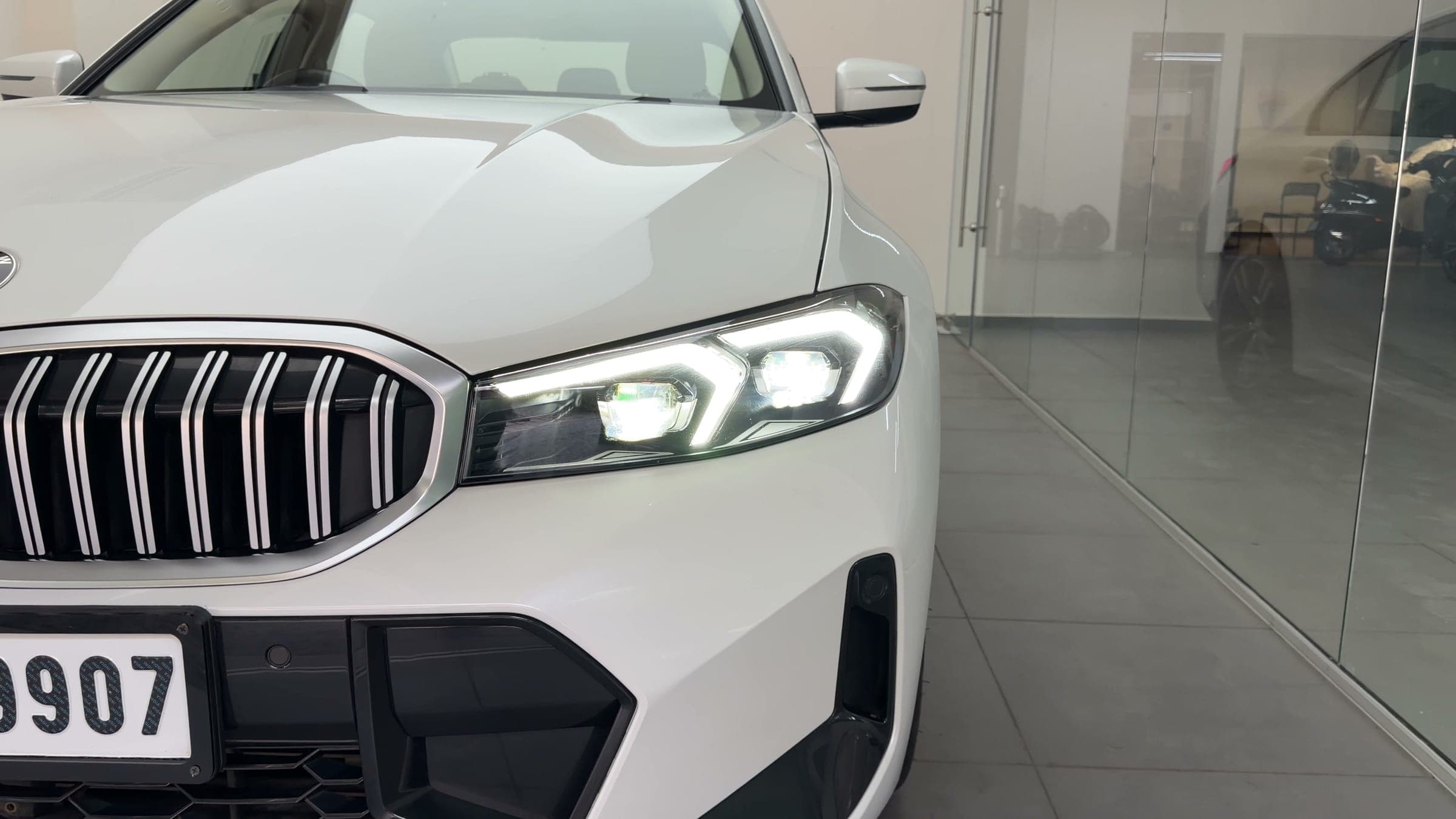 LED headlight and kidney grille of a white BMW 330Li in the studio