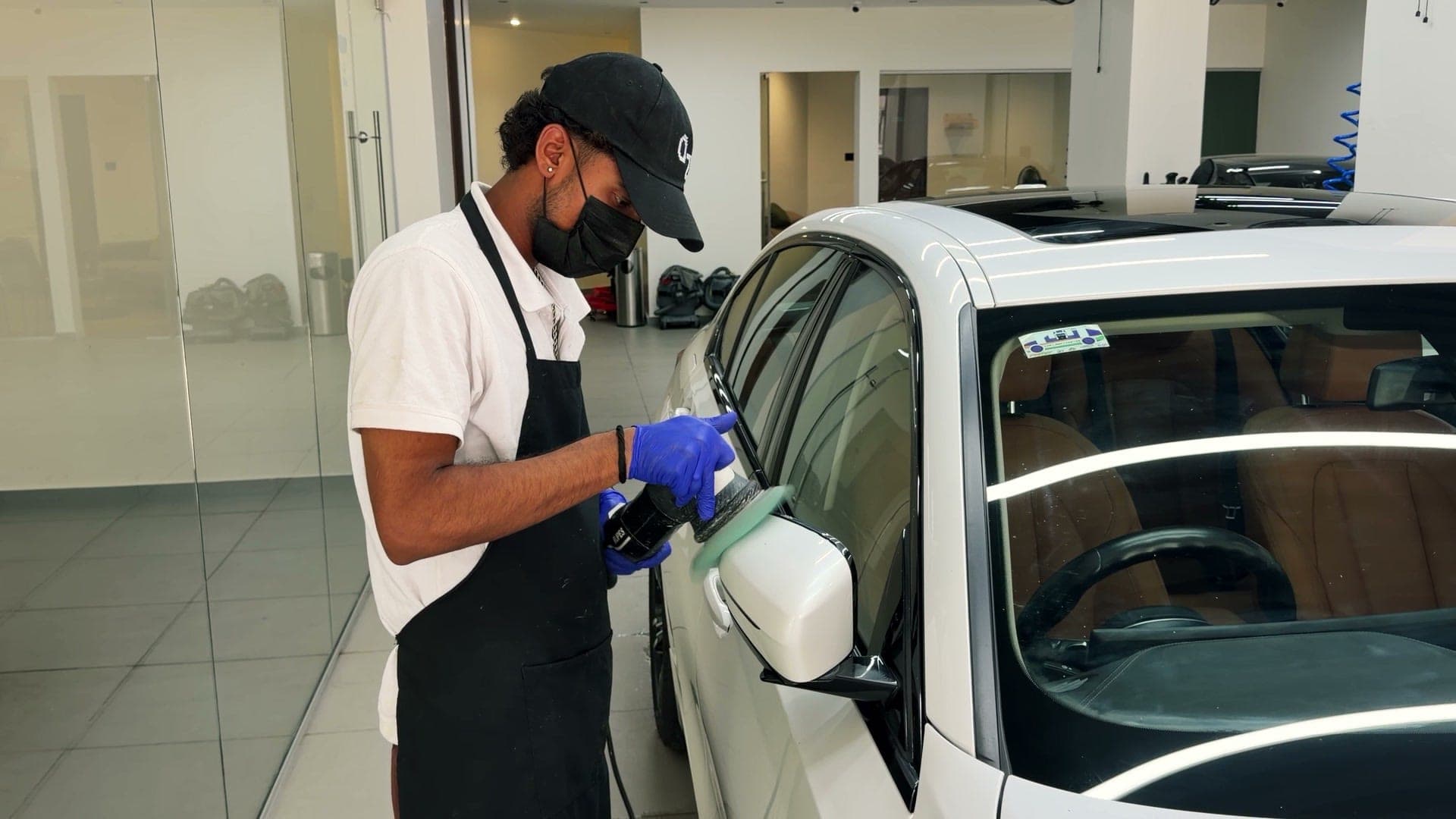 Technician working on the side glass of a white BMW 330Li