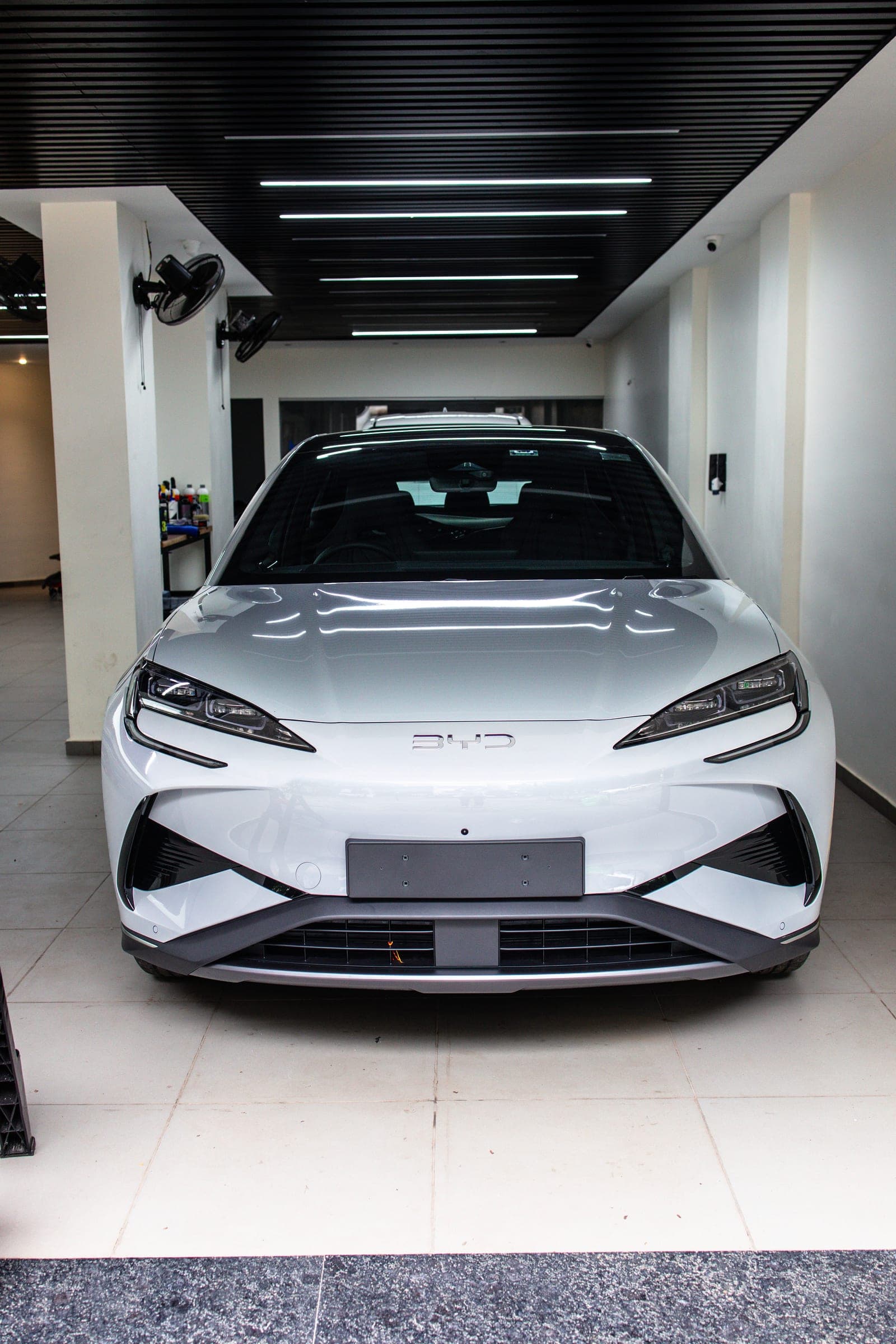 White BYD in the studio beneath the light-box ceiling