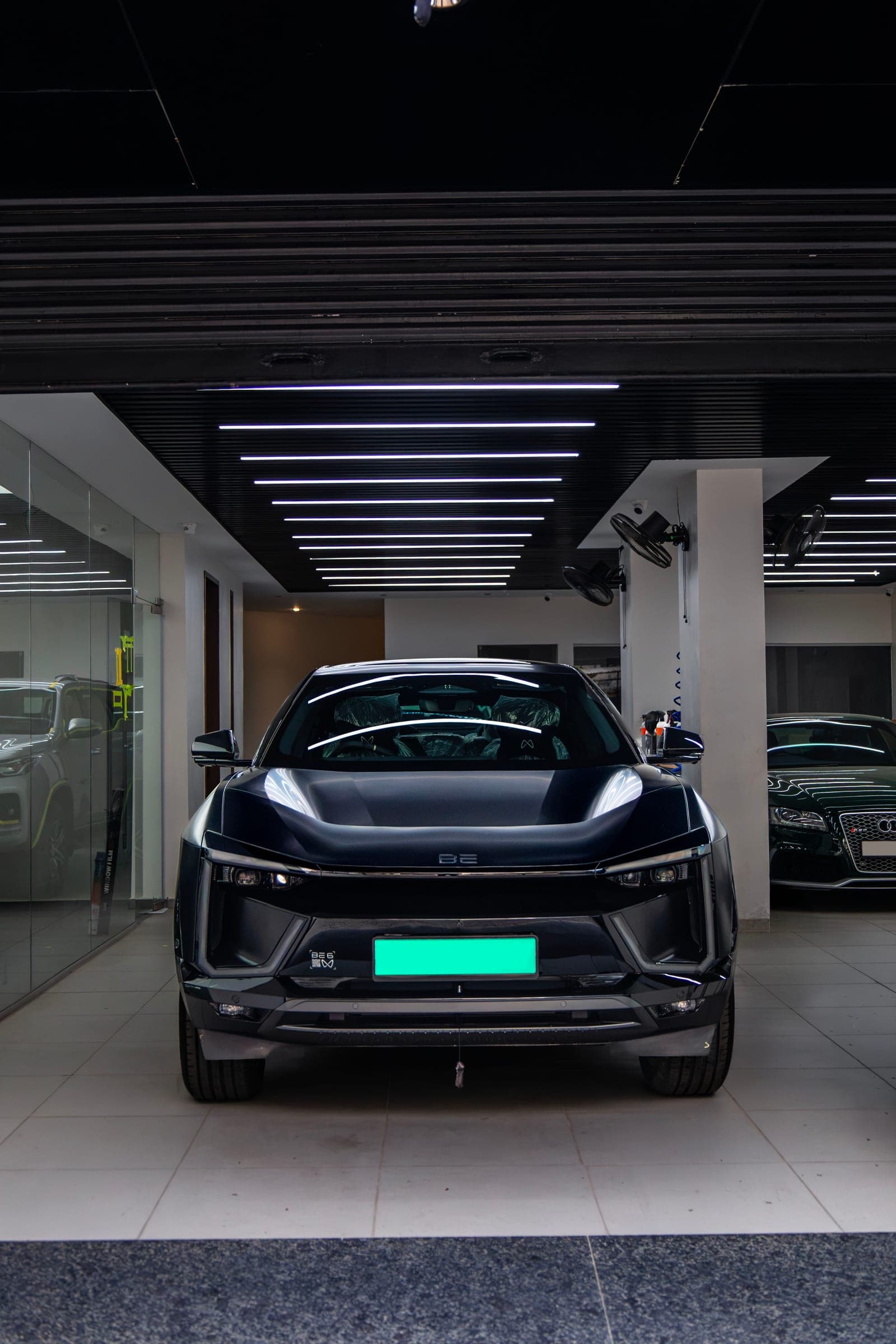 Satin black Mahindra BE 6 under the studio's linear lights