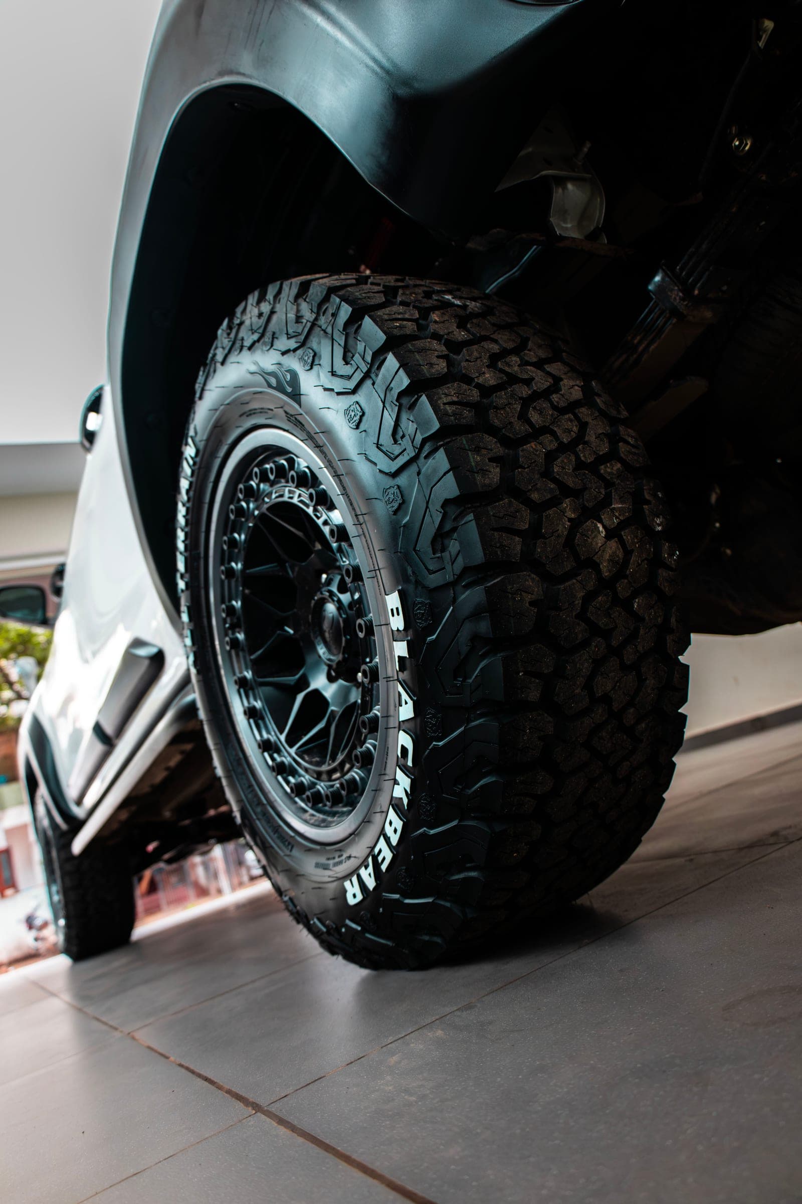 All-terrain tyre and black wheel of a white Toyota Hilux
