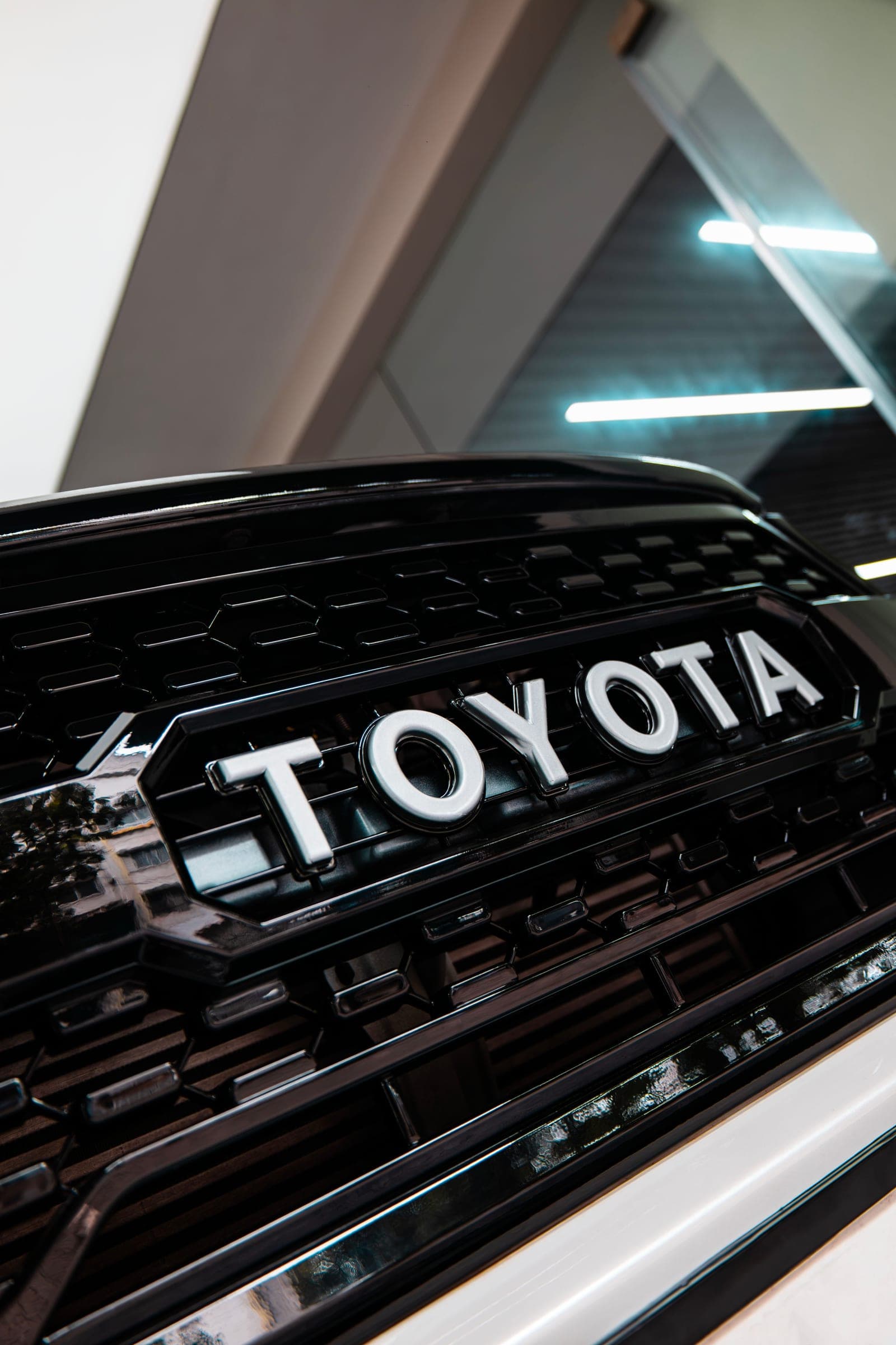 Black TOYOTA grille of a white Hilux