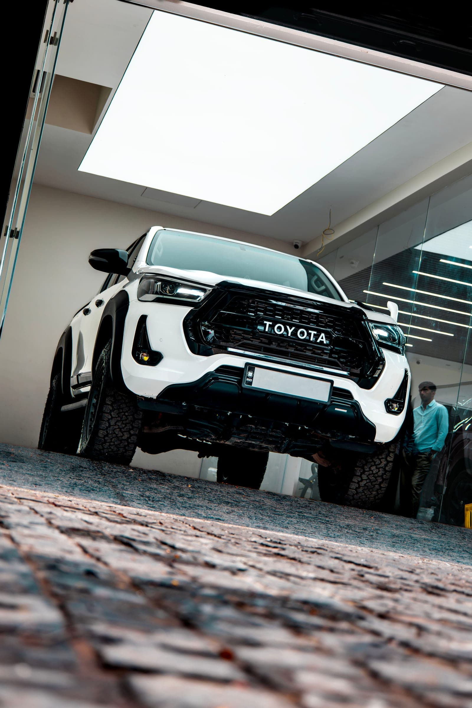 White Toyota Hilux at the studio entrance, low angle